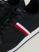 Zapatillas Tommy Hilfiger de estilo running, color azul marino con detalles en blanco y rojo. Confeccionadas en poliuretano y poliéster, con suela de EVA y logo de la marca en el lateral y el talón.