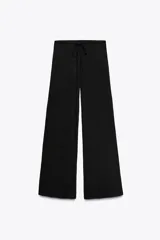 Pantalón negro de tejido texturizado, corte recto, tiro alto y cintura elástica ajustable con cordones.