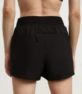 Short deportivo femenino color blanco, de poliéster, con cintura elástica, abertura lateral y bolsillo trasero.