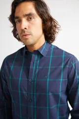 Camisa de hombre a cuadros color beige y azul marino, de corte slim fit, con mangas largas, cartera abotonada y logo bordado en el pecho. Confeccionada en algodón.