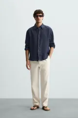 Pantalón verde oscuro de algodón con textura, corte recto, cintura elástica ajustable con cordón, bolsillos laterales y traseros de vivo.