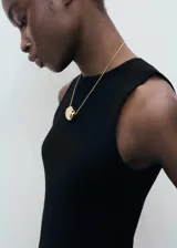 Musculosa negra de tejido de punto fino, con cuello redondo y tirantes anchos.