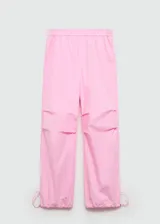 Pantalón parachute rosa con cintura elástica, dos bolsillos laterales y bajo ajustable con goma elástica.