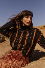 Sweater tejido a mano de algodón con cuello alto y diseño con rayas diagonales en color naranja y detalles en cuero natural.