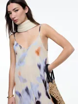 Vestido largo de breteles finos confeccionado en viscosa crinkled con estampa de manchas. De escote en V y silueta evasé, tiene una caída fluida que acompaña el movimiento. El efecto arrugado del tejido le da textura y carácter a una prenda fresca y versátil.