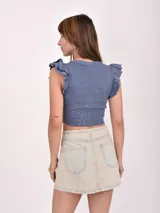 Remera crop top negra de tejido de punto con cuello redondo y mangas cortas con volados.