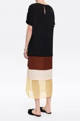Vestido midi con bloques de color: negro en la parte superior, marrón en el centro y beige con estampado de cachemir en la parte inferior. Tiene escote redondo y mangas cortas.