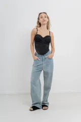 Pantalón de jean celeste de tiro medio y corte wide leg, con strass aplicados en el frente.