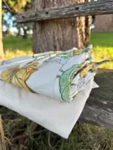 Pantalón corto de vestir color crudo con estampado de hojas verdes y amarillas.