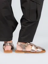 Sandalia de cuero negro con tiras trenzadas y hebilla ajustable.