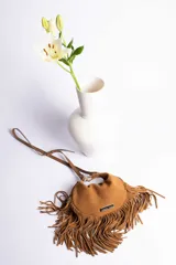 Bandolera marrón de gamuza con flecos largos y correa fina ajustable.