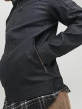 Campera negra de cuero sintético con cuello mao, cierre frontal con cremallera, bolsillos laterales y en el pecho con cremallera, mangas largas con detalle de costuras en los hombros.