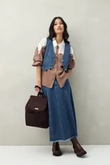 Camisa de lino color crudo y beige, con diseño bicolor y recorte ondulado en el canesú. De silueta relajada, cuenta con mangas amplias y puños camiseros. Se completa con botones de nácar.