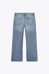 Pantalón de jean celeste de tiro bajo, corte flare, cropped y cinco bolsillos.