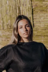 Blusa color crudo de lino natural, corte holgado, con cuello redondo y mangas 3/4 con ribete azul.