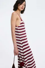 Vestido largo de punto con rayas horizontales blancas y negras, breteles finos y falda acampanada.