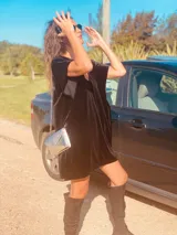 Vestido corto negro de terciopelo con bordado de flores blancas en la espalda, escote en V y corte holgado.