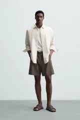 Bermuda negra de lino con calce relajado. Presenta cintura elástica ajustable con cordón, bolsillos frontales y un bolsillo trasero de plastrón.