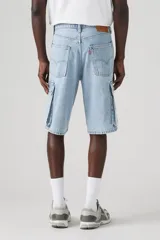 Bermuda de jean celeste claro, corte holgado, con bolsillos cargo laterales y bolsillos delanteros y traseros.