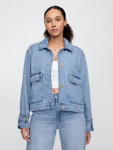 Campera de jean celeste, corte recto, con cuello clásico, cierre frontal con botones, mangas largas con puños abotonados, bolsillos de parche con solapa en el pecho y bolsillos laterales.