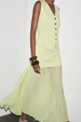 Chaleco color verde claro de punto con escote pico y cierre frontal con botones dorados.