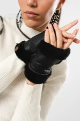 Guantes mitones negros de cuero con borde de lana natural.
