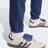 Pantalón de jogging azul marino de felpa, con corte ajustado, cintura elástica con cordón, bolsillos laterales y puños acanalados. Logo del trifolio bordado en blanco en la pierna izquierda.