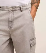 Bermuda masculina de jean color gris oscuro, corte holgado, con bolsillos cargo laterales, trabillas en la cintura y cierre con botón y cremallera.