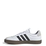 Zapatillas de corte clásico en color blanco con detalles en negro y gris, de la marca Adidas.