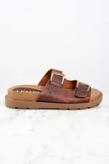 Sandalias de cuero marrón con doble tira y hebillas doradas.