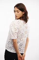 Blusa blanca con mangas cortas abullonadas y bordado calado con motivos florales. Incluye musculosa blanca para usar debajo.