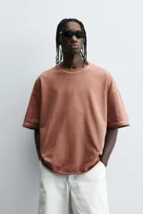 Camiseta color beige de corte holgado, cuello redondo y manga corta.