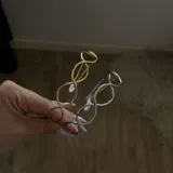 Brazalete dorado con diseño de eslabones entrelazados.