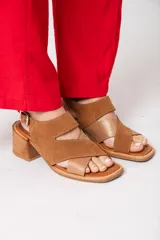 Sandalias de cuero color tostado, con plataforma de 1 cm y taco cuadrado de 6 cm. Presenta tiras cruzadas en el empeine, una tira ancha con abertura en el frente y pulsera con hebilla.