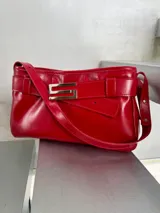 Cartera de cuero rojo con aplique metálico plateado con forma de S.