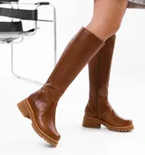 Bota de caña alta color marrón, confeccionada en cuero vacuno. Tiene suela de goma sport artesanal, cierre YKK del lado interno y horma de punta redonda.