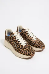 Zapatillas deportivas con estampado animal print, confeccionadas con piezas de piel con pelo. Lengüeta con etiqueta logotipada y parte trasera de piel con adorno metálico logotipado. Nuevo piso con estabilizador personalizado, entresuela de eva y suela bicolor con acabado dentado y logo.