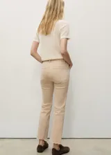 Pantalón de jean color beige, de corte recto, tiro medio y largo cropped. Presenta bajo deshilachado y cinco bolsillos.