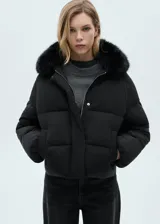 Campera puffer negra con cuello de piel sintética removible, cierre frontal con cremallera y botones a presión, bolsillos laterales con ribete, mangas largas con puños elásticos, diseño crop, acolchado, oversize y forro interior.