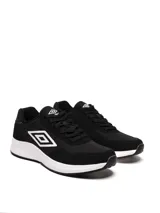 Championes Umbro modelo Volcan, color negro con detalles en blanco. Presentan un diseño deportivo con capellada de tela y gamuza, entresuela blanca gruesa y el logo Umbro en el lateral.