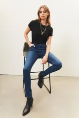 Jean slim de tiro medio confeccionado en denim azul con lavado localizado y apliques hotfix en los bolsillos delanteros.