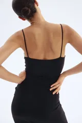 Vestido midi negro de punto interlock pesado, con breteles finos y escote drapeado tipo cowl neck. Presenta frunces laterales que crean un efecto drapeado en la cadera.