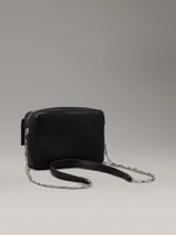 Bandolera negra de cuero sintético con correa de cadena plateada y logo CK plateado en el frente.