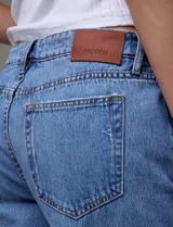 Jean de tiro alto de calce relajado, color azul denim. Tiene pretina con pasadores, botón y cierre. Delantera y trasera con bolsillos. Recortes verticales en el frente y recorte horizontal en el ruedo.