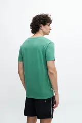 Remera básica de corte regular, color verde, fabricada en algodón, con un diseño sencillo ideal para el uso diario.