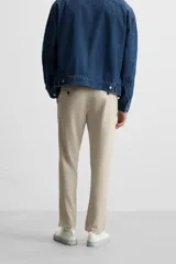 Pantalón slim fit negro confeccionado en tejido con elasticidad en ambas direcciones. Cuenta con bolsillos frontales y traseros de vivo con botón. Cierre frontal con cremallera y botón.