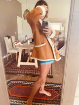 Campera gamulan color camel de cuero italiano con interior de piel sintética blanca. Tiene cuello solapa amplio, cierre con botones y bolsillos laterales.