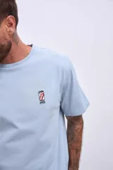 Remera celeste de corte recto y manga corta, con pequeño estampado de una lata en el pecho.