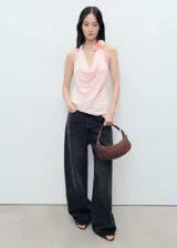 Blusa sin mangas color rosa, con cuello drapeado y detalle de flores en el cuello.