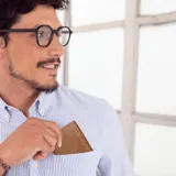 Billetera marrón de cuero con bolsillo al frente, tarjetero extraíble con elástico, doble compartimento para billetes, tarjeteros y bolsillos.